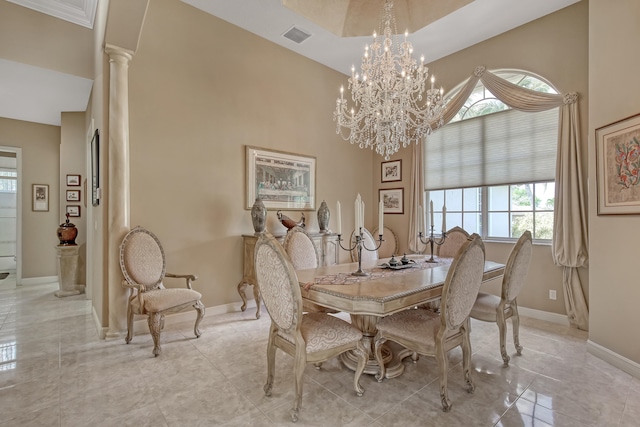 dining space featuring decorative columns, light tile floors, a towering ceiling, and an inviting chandelier