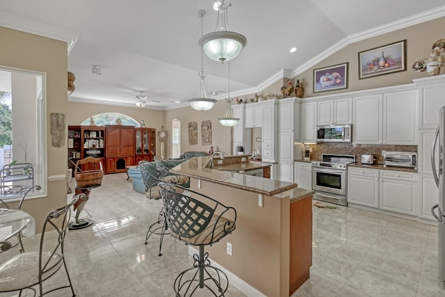 kitchen featuring pendant lighting, white cabinets, stainless steel appliances, light stone counters, and ceiling fan