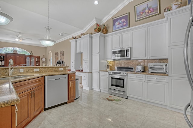 kitchen with ceiling fan, stainless steel appliances, vaulted ceiling, white cabinetry, and sink