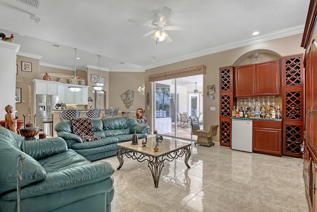 tiled living room with ornamental molding, bar, and ceiling fan