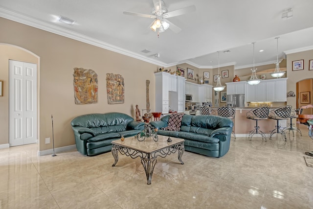 tiled living room with ceiling fan and crown molding