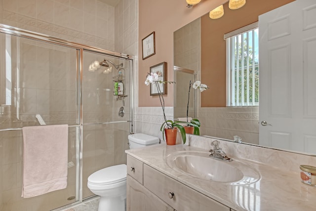 bathroom featuring tile walls, large vanity, an enclosed shower, and toilet