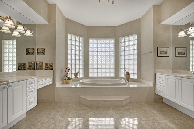 bathroom with a tub, a wealth of natural light, and vanity