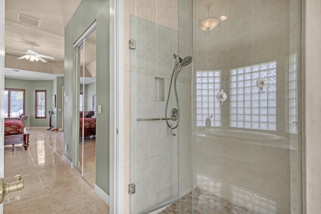 bathroom with walk in shower, tile flooring, ceiling fan, and a textured ceiling