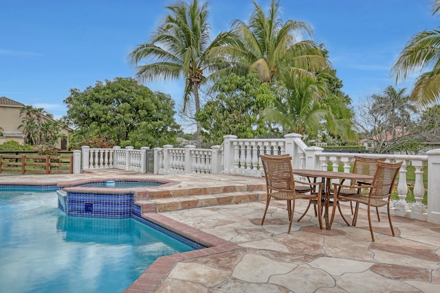 view of pool featuring a patio and an in ground hot tub