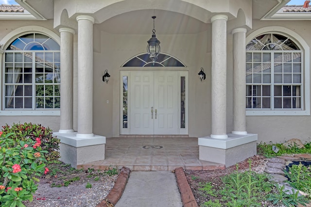 view of exterior entry featuring covered porch