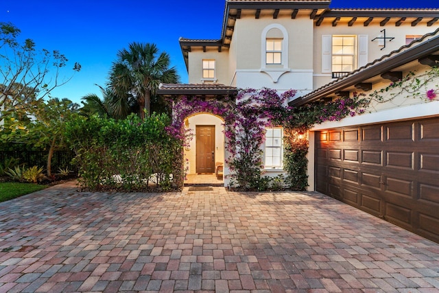 mediterranean / spanish home featuring a garage and a lawn