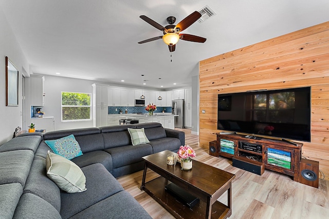 living room featuring ceiling fan and light hardwood / wood-style floors