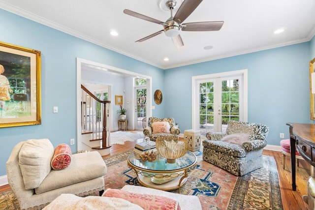 living room with ornamental molding, hardwood / wood-style floors, ceiling fan, and french doors