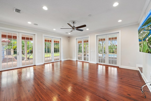 unfurnished living room with french doors, dark wood-type flooring, a textured ceiling, and crown molding