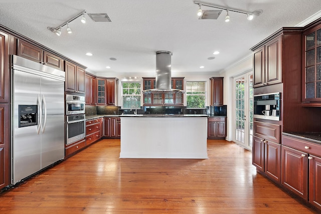 kitchen featuring light hardwood / wood-style flooring, island exhaust hood, sink, and stainless steel appliances