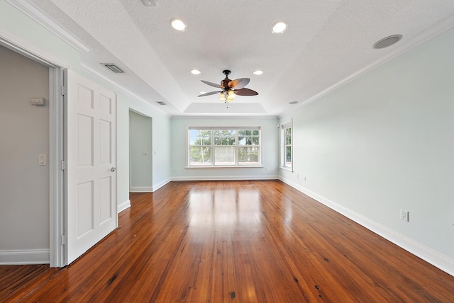 spare room featuring ornamental molding, ceiling fan, a textured ceiling, a tray ceiling, and dark wood-type flooring