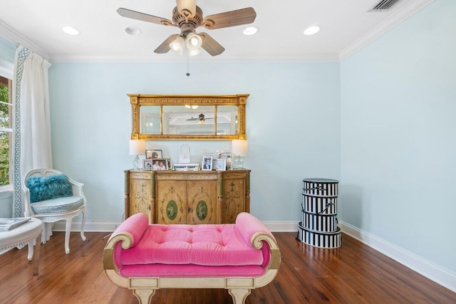 sitting room with ceiling fan, crown molding, and dark hardwood / wood-style flooring