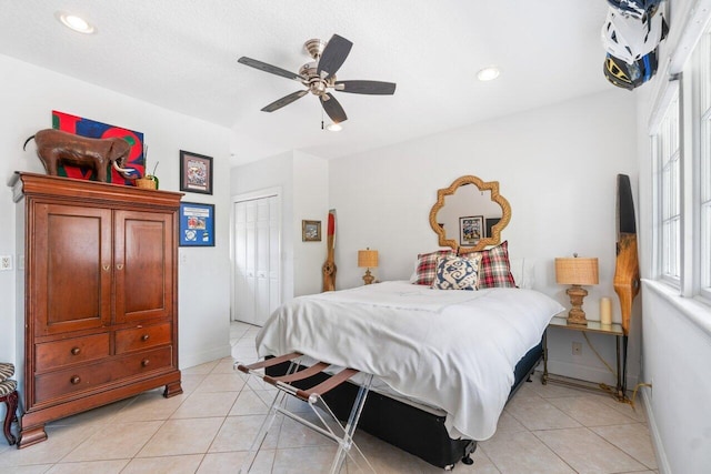 bedroom with light tile patterned flooring, ceiling fan, and a closet