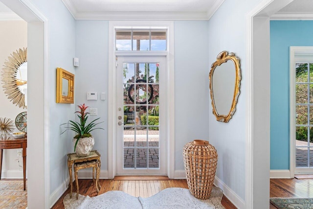 entryway with light hardwood / wood-style flooring and crown molding