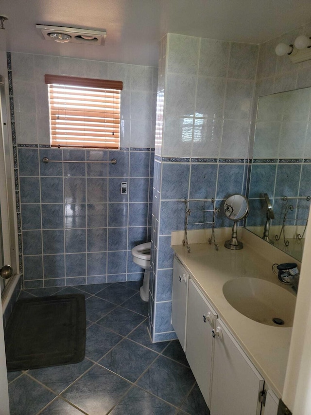 bathroom featuring tile patterned floors, toilet, tile walls, and vanity