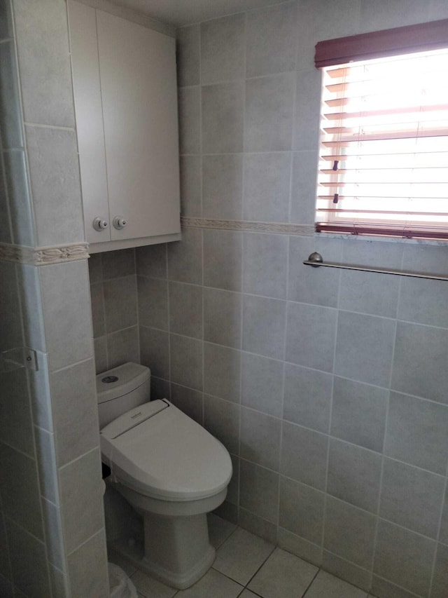 bathroom with tile patterned floors, toilet, and tile walls