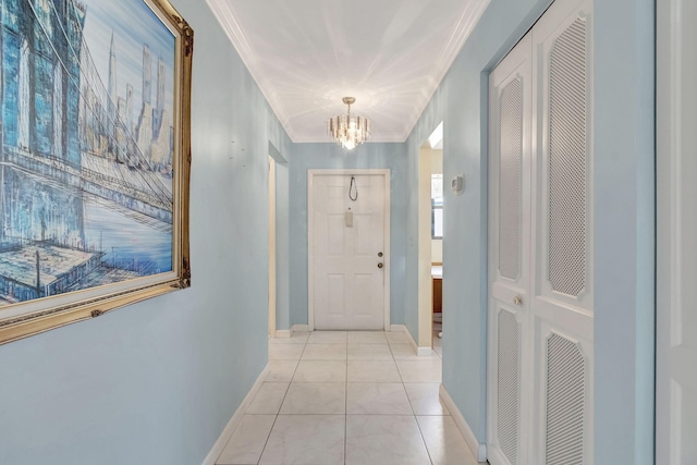 hallway featuring light tile patterned floors, crown molding, and an inviting chandelier