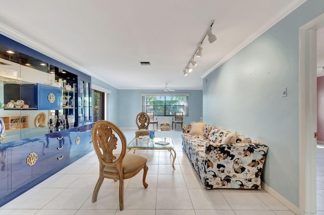 tiled dining area with rail lighting, ceiling fan, and crown molding