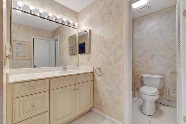 bathroom with tile patterned flooring, vanity, a textured ceiling, and toilet