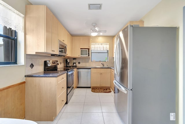 kitchen with light brown cabinetry, stainless steel appliances, ceiling fan, sink, and light tile patterned floors