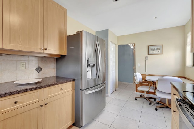 kitchen with light brown cabinets, light tile patterned flooring, stainless steel fridge with ice dispenser, and backsplash