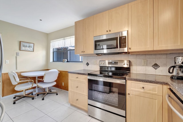 kitchen with backsplash, light brown cabinets, light tile patterned floors, and stainless steel appliances