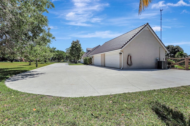 view of property exterior with a yard, a garage, and central air condition unit