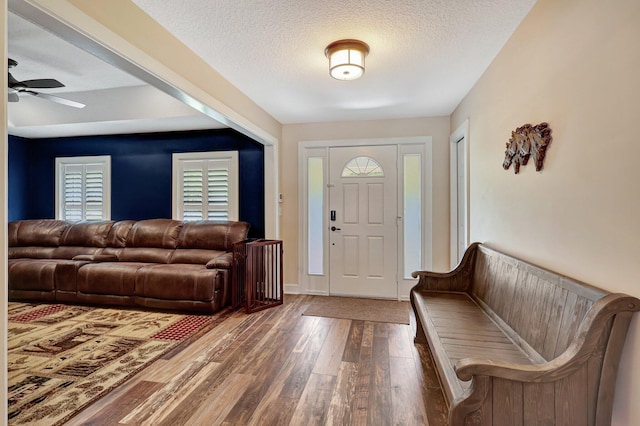 entrance foyer featuring a healthy amount of sunlight, wood-type flooring, ceiling fan, and a textured ceiling