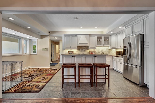 kitchen featuring stainless steel appliances, white cabinetry, and a raised ceiling