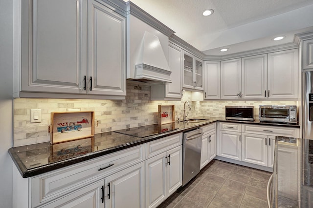 kitchen featuring custom range hood, tasteful backsplash, tile flooring, appliances with stainless steel finishes, and sink