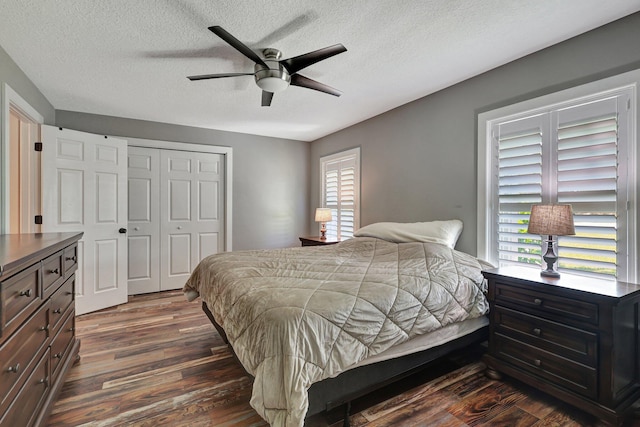 bedroom with a textured ceiling, a closet, ceiling fan, and dark hardwood / wood-style floors