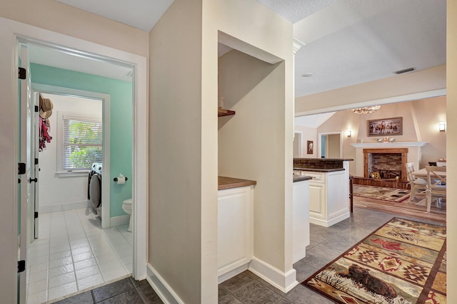 corridor with dark tile flooring and washer / clothes dryer