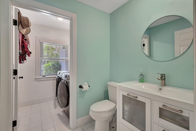 bathroom with vanity, toilet, tile floors, and washing machine and clothes dryer