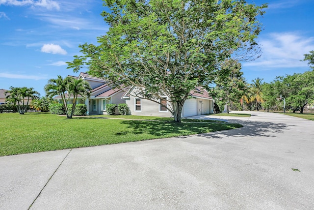 obstructed view of property featuring a garage and a front yard