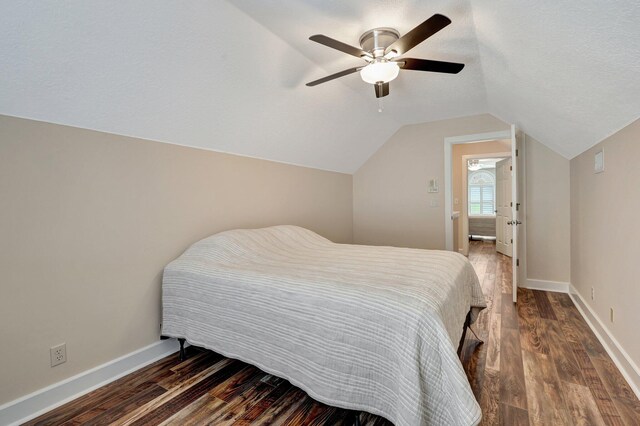 bedroom featuring ceiling fan, dark hardwood / wood-style flooring, a textured ceiling, and lofted ceiling