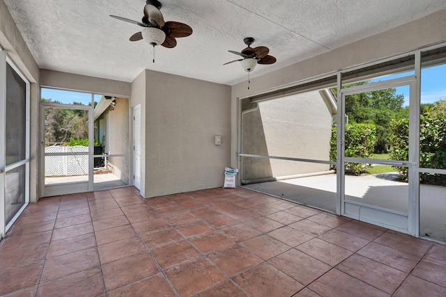 unfurnished sunroom with ceiling fan