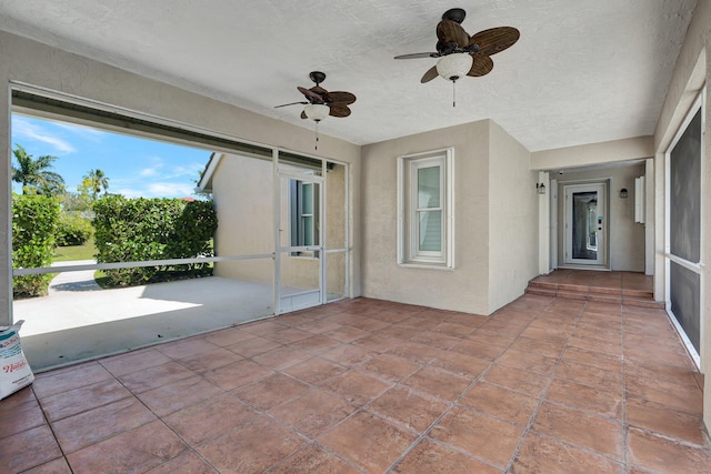 unfurnished sunroom featuring ceiling fan