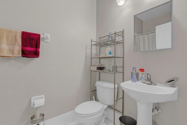 bathroom featuring toilet and tile floors