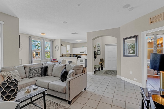 living room with light tile flooring and a textured ceiling