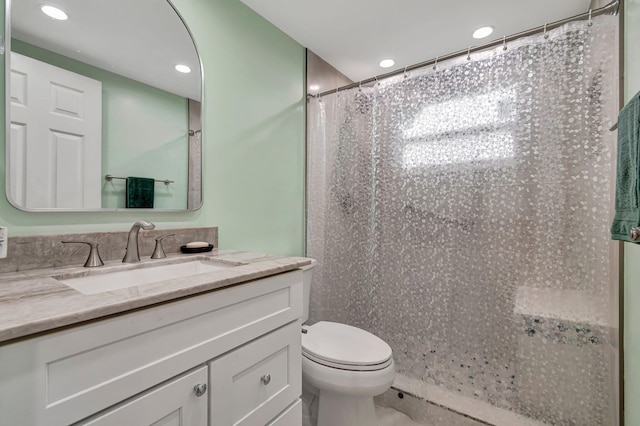 bathroom featuring walk in shower, vanity, and toilet