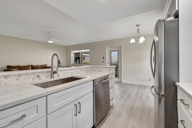 living room featuring light hardwood / wood-style flooring, ceiling fan, and sink