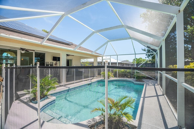 view of swimming pool featuring a patio area, ceiling fan, and glass enclosure