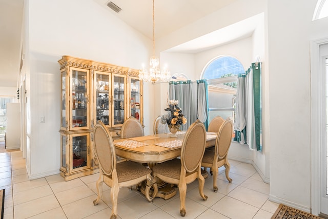 tiled dining space with high vaulted ceiling and a notable chandelier