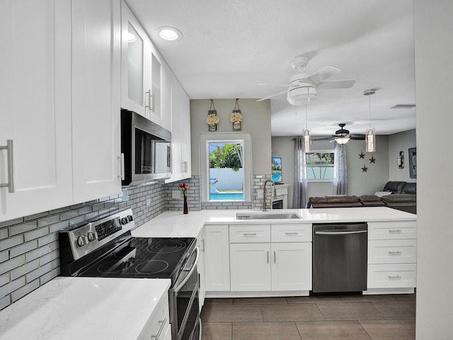 kitchen featuring white cabinets, decorative backsplash, stainless steel appliances, and sink