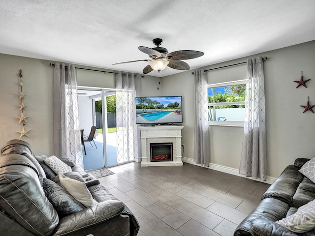 living room with ceiling fan and a textured ceiling