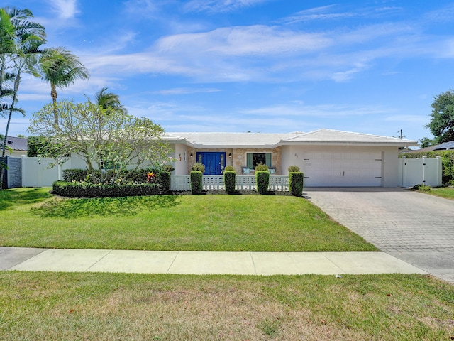 ranch-style house featuring an attached garage, fence, decorative driveway, stucco siding, and a front lawn