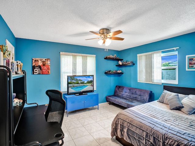 tiled bedroom featuring ceiling fan and a textured ceiling