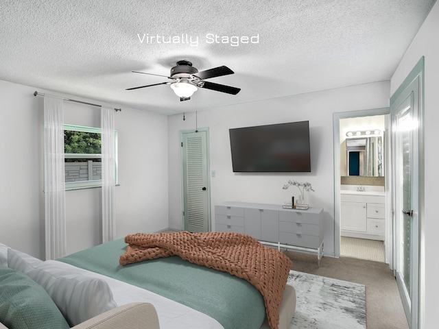 carpeted bedroom with connected bathroom, ceiling fan, sink, and a textured ceiling