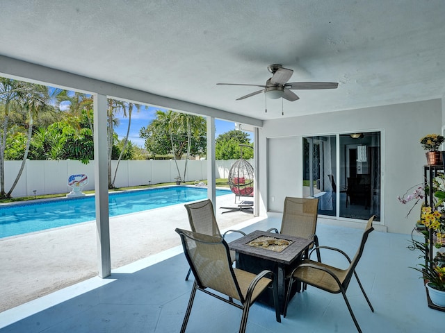 view of swimming pool with a patio area, ceiling fan, and a fire pit